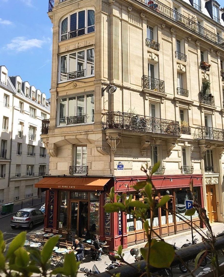 Vue plongeante sur la façade d'angle et la terrasse du Pure Café, rue Jean-Macé